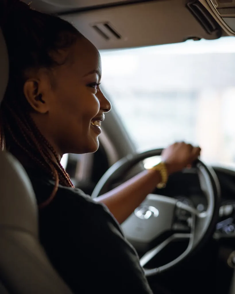 Smiling woman driving car, enjoying the road, auto insurance concept.