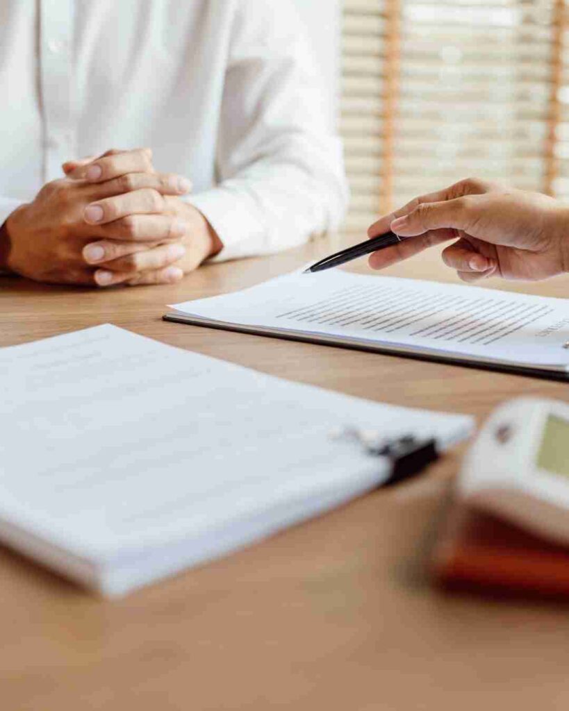Person discussing insurance documents with an agent at a desk.
