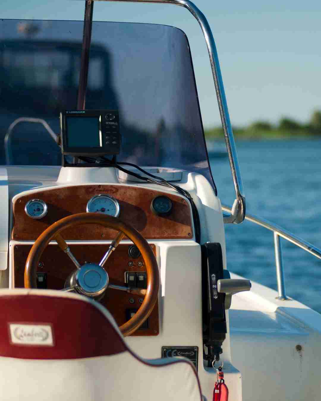 Close-up of boat dashboard with navigation equipment on water.