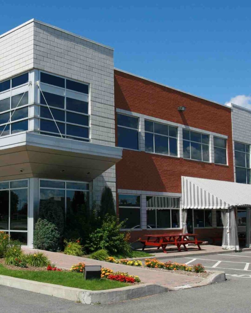 Contemporary commercial building with large windows and outdoor seating area.