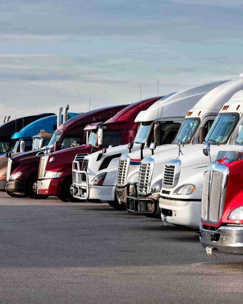Lineup of semi-trucks parked in a lot for commercial trucking.