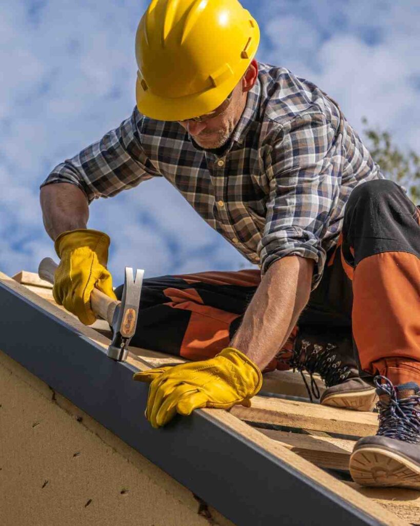 Skilled roofing contractor installing shingles on a roof with safety gear.