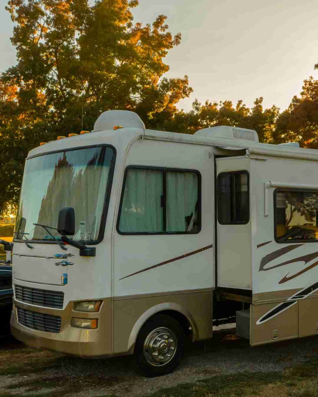 White RV parked outdoors with trees in the background, ideal for RV insurance.